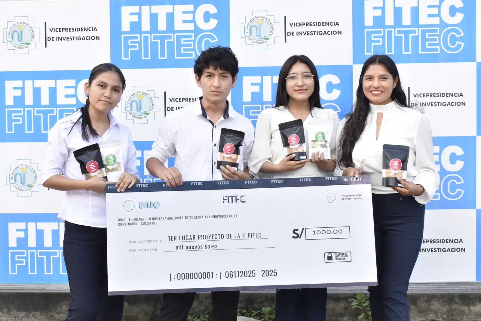 Cuatro estudiantes con el cheque del proyecto ganador de la II FITEC